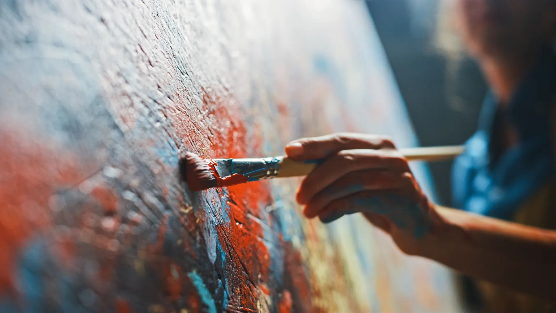 Hand with red brush on canvas