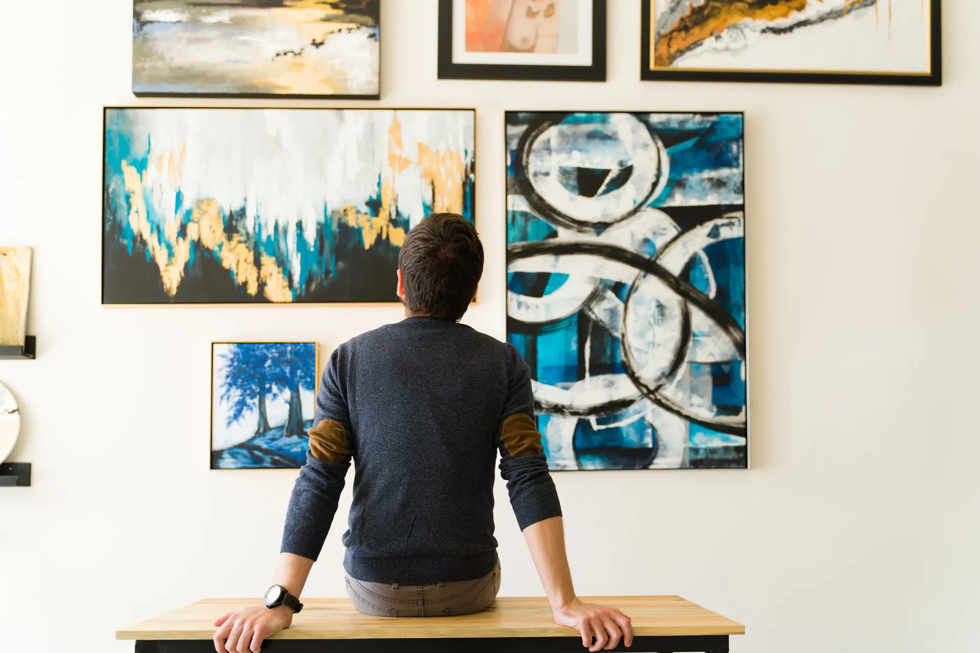 Man looking at paintings in gallery